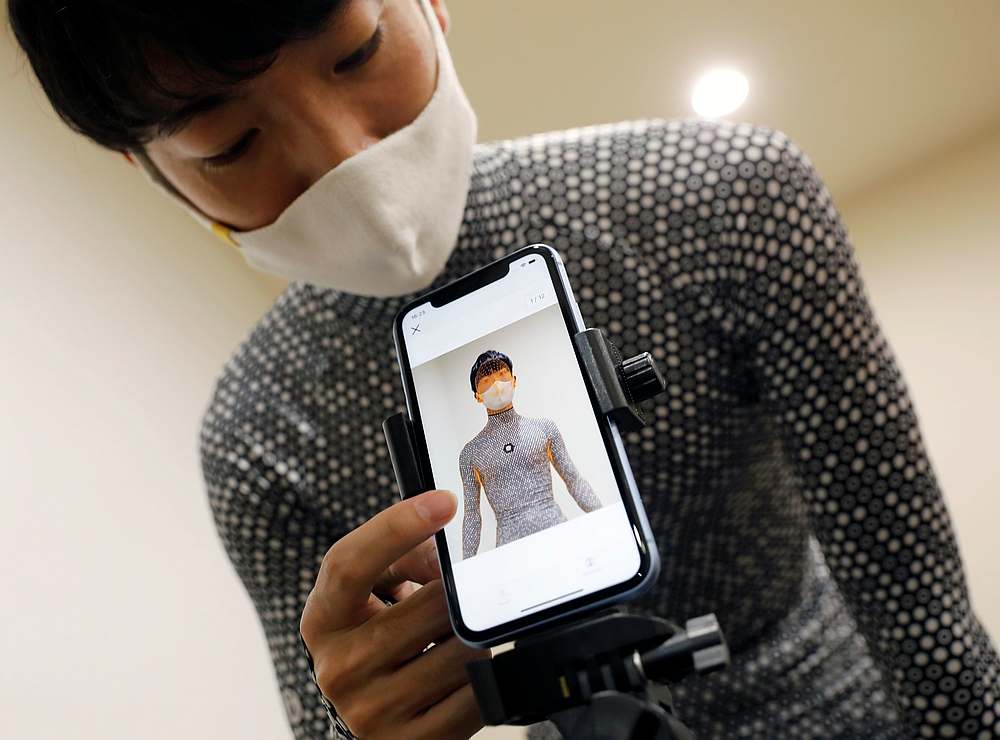 An employee of online fashion retailer Zozo Inc demonstrates the company's Zozosuit 2, a 3D body measurement suit, at their Tokyo office in Tokyo, Japan October 30, 2020. u00e2u20acu201d Reuters pic