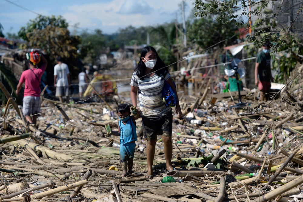 A woman and a child walk on debris brought by the flood following Typhoon Vamco, in Rodriguez, Rizal province, Philippines, November 13, 2020. u00e2u20acu201d Reuters pic 