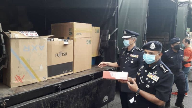 Johor police chief Datuk Ayob Khan Mydin Pitchay (right) with contraband cigarettes that were scheduled to be disposed of by the authorities following the completion of the cases. u00e2u20acu201d Picture by Ben Tan