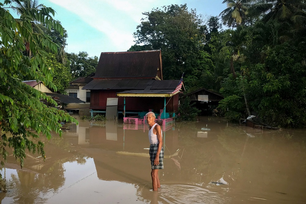 An elderly man wades in flood water outside his house at Kampung Bukit Tambun in Alor Gajah November 20, 2020. u00e2u20acu201d Bernama pic