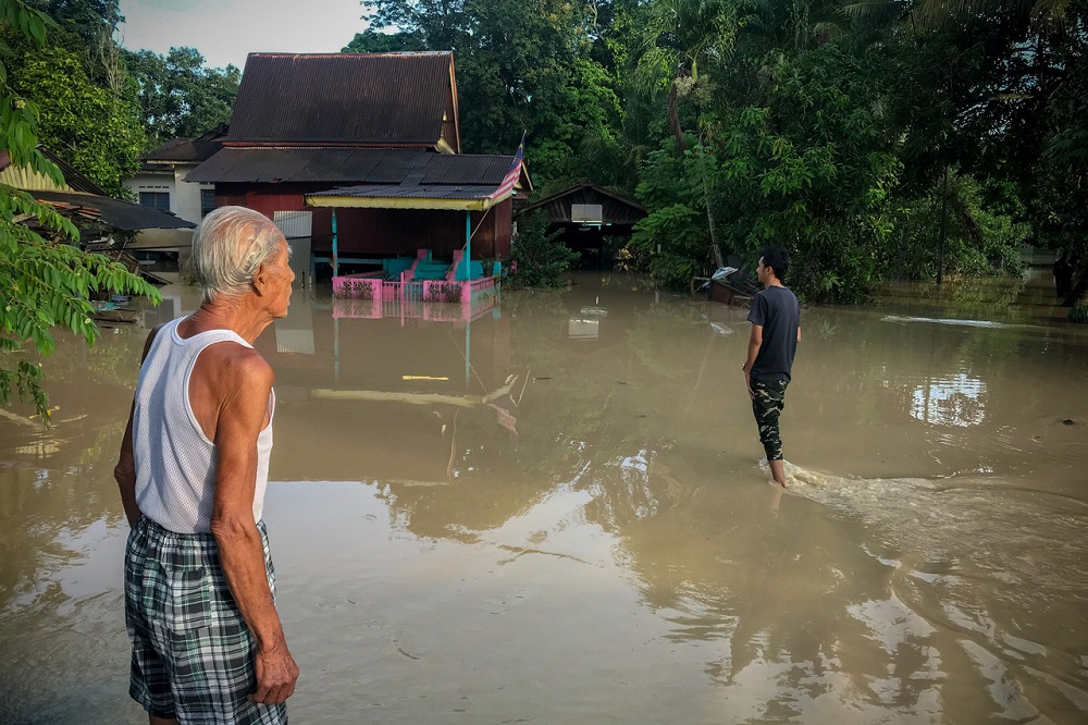 Kampung Bukit Tambun residents wade in flood water outside their house in Alor Gajah November 20, 2020. u00e2u20acu201d Bernama pic
