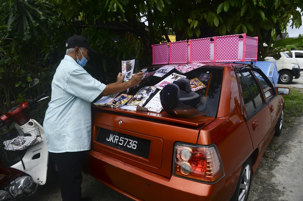 A man lays out sheets of papers to dry after his home was affected by the flood at Kampung Seri Jaya in Tampoi Utama, Johor Baru November 22, 2020. u00e2u20acu201d Bernama pic