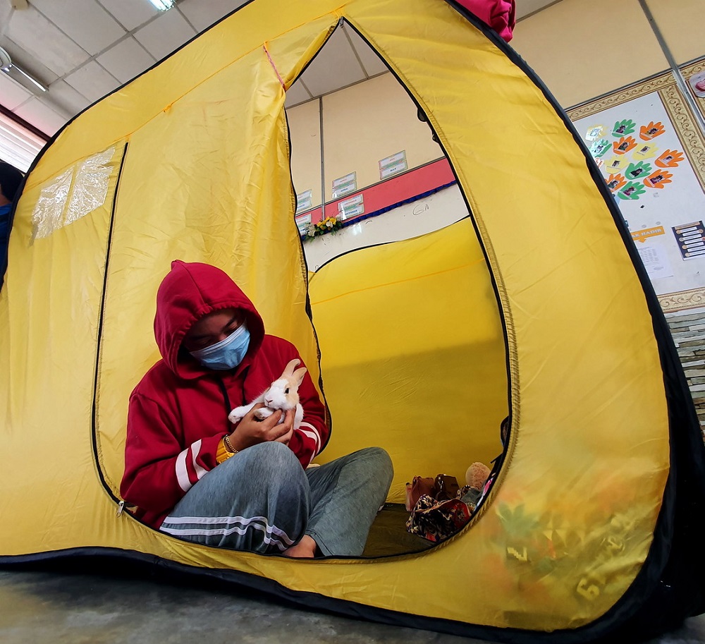 A flood victim plays with her pet rabbit at the relief centre in Sekolah Rendah Ayer Molek in Melaka November 22, 2020. u00e2u20acu201d Bernama pic