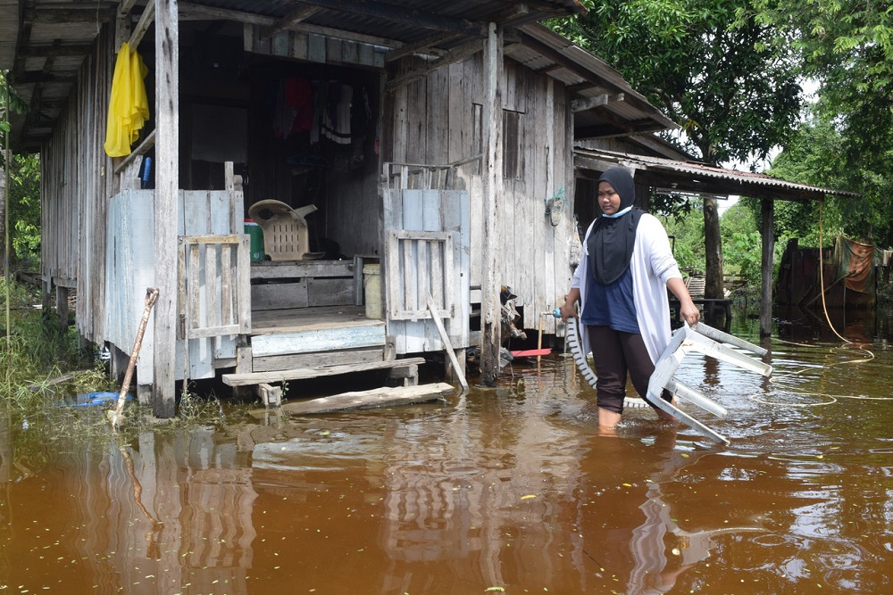 A woman wades in flood water outside her house in Kampung Padang Garam, Marang November 29, 2020. u00e2u20acu201d Bernama pic