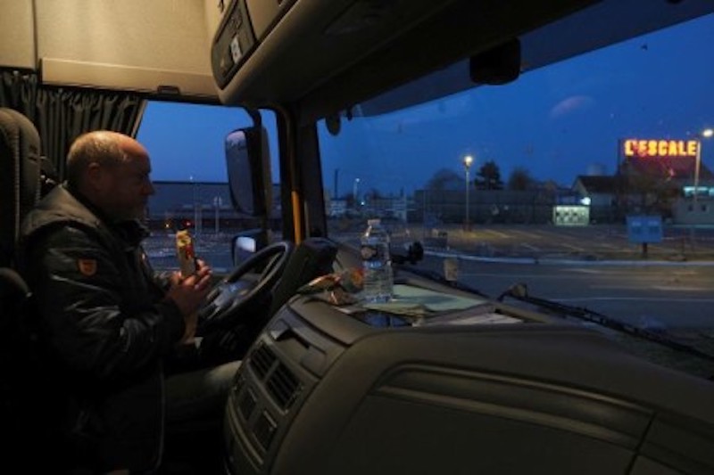 A truck driver eats inside his cabin on the parking of the closed truck drivers restaurant Lu00e2u20acu2122Escale. u00e2u20acu201d AFP-Relaxnews pic