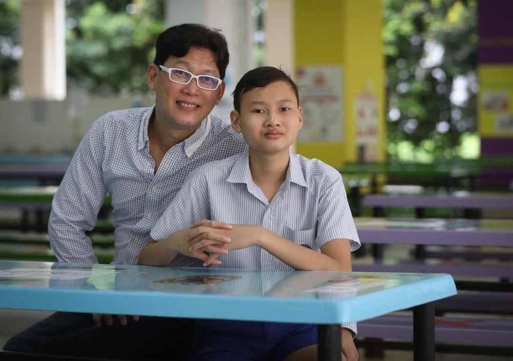 Teh Jun Hang and his father Nicholas Teh. After a long road to recovery, Jun Hang, now aged 13, was one of the 39,995 Primary 6 pupils who collected their Primary School Leaving Examination results on Wednesday. u00e2u20acu201d TODAY pic