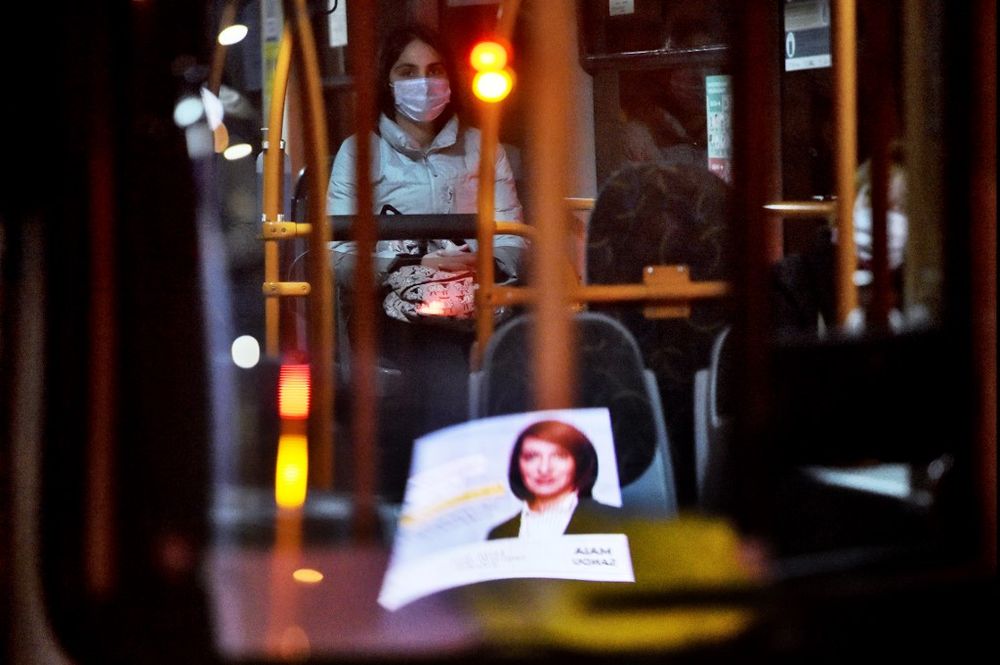 A woman wearing a face mask rides a trolleybus as a campaign poster of pro-European Moldovan presidential candidate Maia Sandu, leader of the Party of Action and Solidarity is reflected in the windscreen in Chisinau, November 13, 2020. u00e2u20acu201d AFP pic