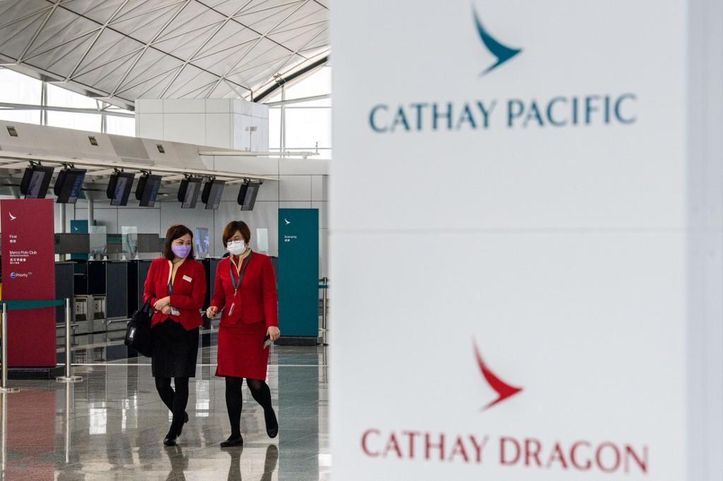 Employees walking past signage for Cathay Pacific near the flagship carrier's check-in counters at Hong Kong International Airport on October 20, 2020. u00e2u20acu2022 AFP pic via TODAY