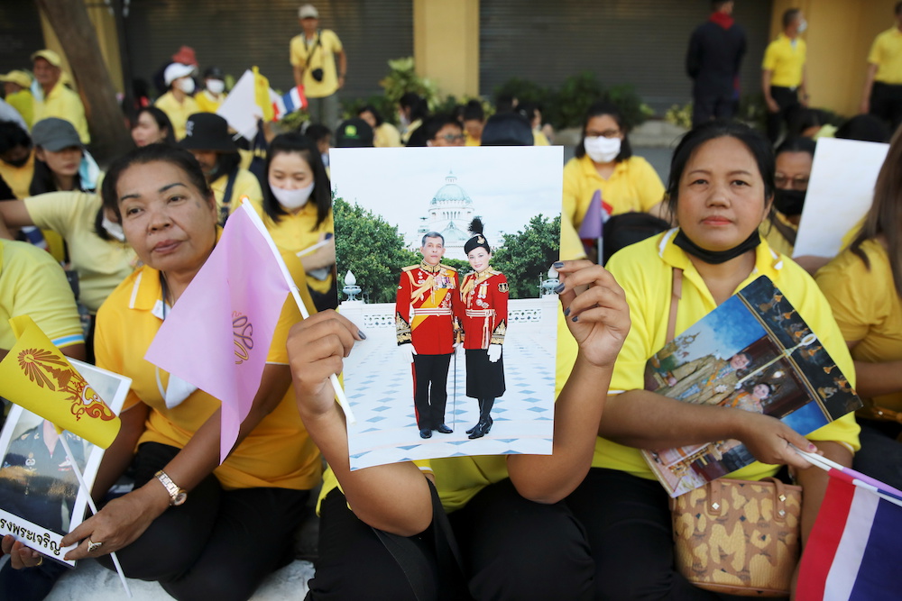 A royalist holds a photo of Thailandu00e2u20acu2122s King Maha Vajiralongkorn and Queen Suthida near the site of a rally to call for the ouster of Prime Minister Prayuth Chan-ochau00e2u20acu2122s government and reforms in the monarchy in Bangkok, Thailand, November 14, 2020. u00e2u20acu2022