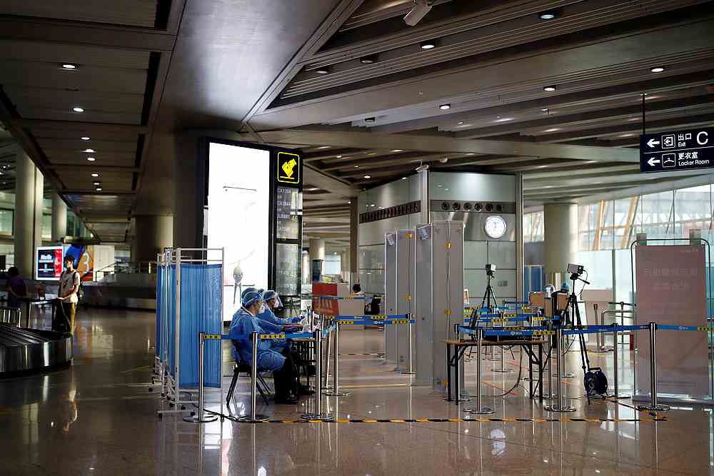 Staff members in protective suits sit at a checkpoint at Beijing Capital International Airport, following Covid-19 infections, in Beijing, China June 16, 2020. u00e2u20acu201d Reuters pic