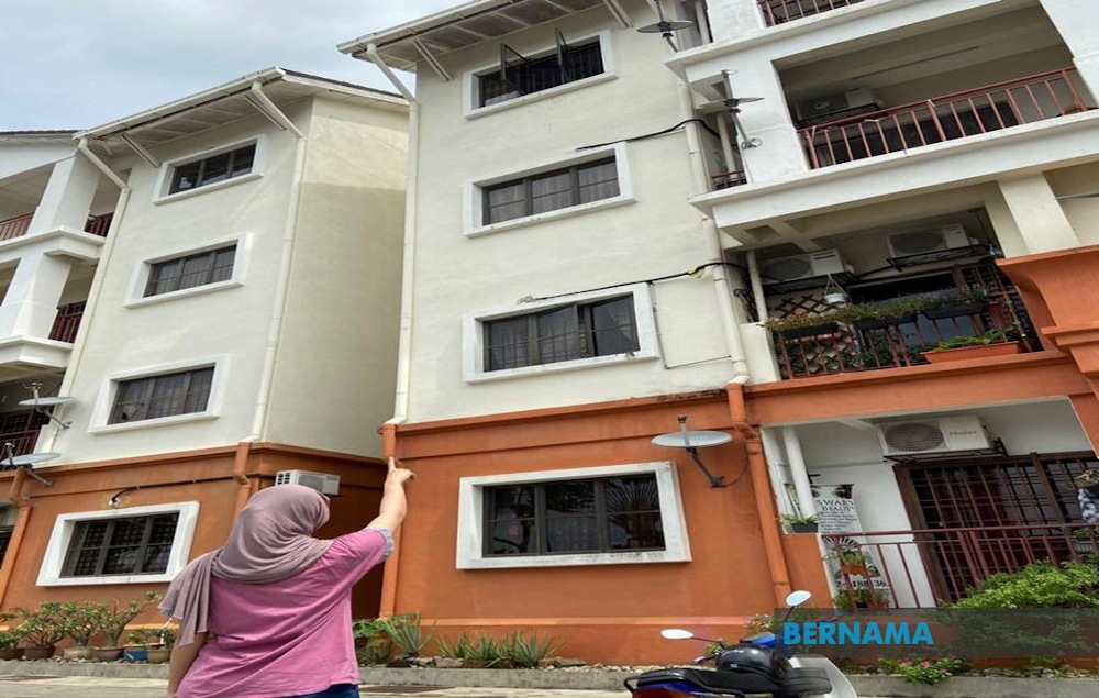 A woman points towards the appartment where a man was arrested for allegedly throwing his four-year-old step-grandson out of a window in Danau Kota, Setapak November 29, 2020. — Picture via Twitter/Bernama