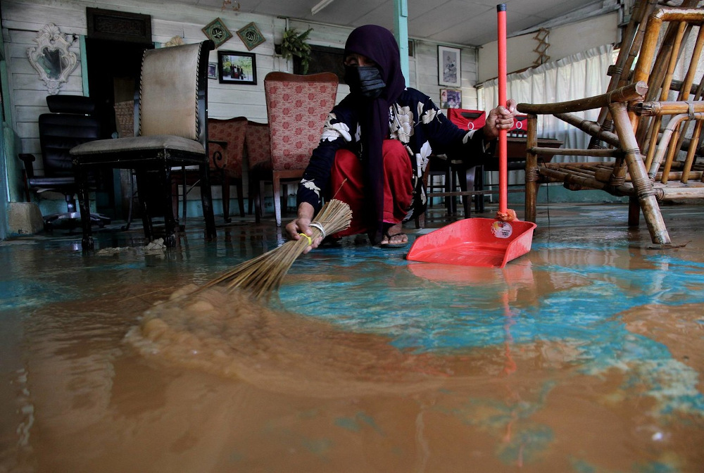 Siti Aishah Ahmad, 80, cleans the mud in her house after floods in Kampung Sungai Kati, Manjoi November 29, 2020. u00e2u20acu201d Bernama pic