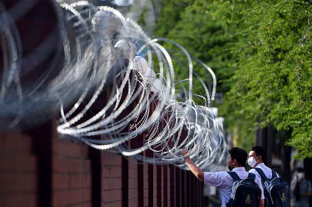 Students walk next to barbwire ahead of a mass rally to call for the ouster of Prime Minister Prayuth Chan-ocha's government and reforms in the monarchy, at the Crown Property Bureau in Bangkok, Thailand, November 24, 2020. u00e2u20acu201d Reuters pic