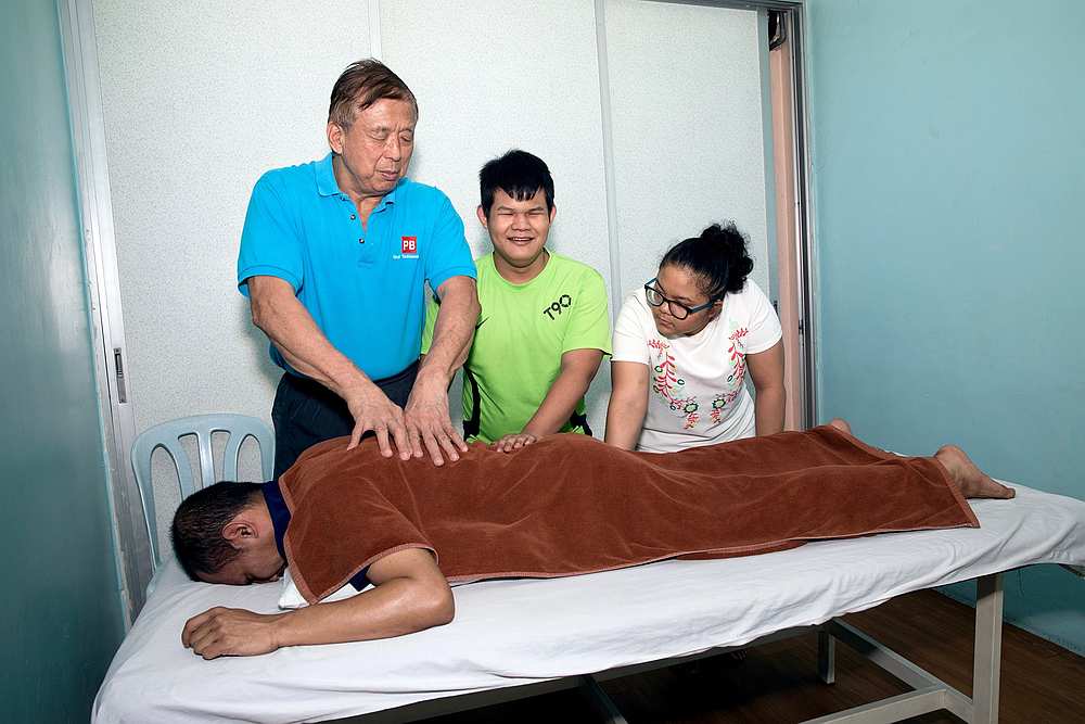Former Paralympian Lee Seng Chow (standing left) now operates a massage centre in Brickfields and employs 33 masseurs. — Photo via Facebook/ PB Blind Massage