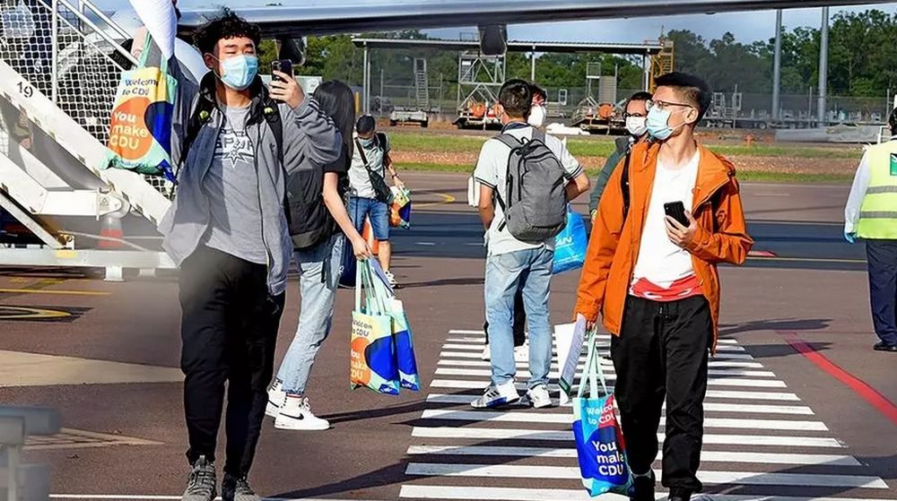 Foreign students disembark from an international flight at Darwin Airport, the first such arrivals since Australia's border closure in March. u00e2u20acu201d Charles Darwin University/AFP pic
