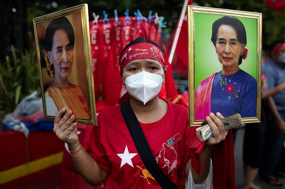 A National League for Democracy (NLD) supporter holds two portraits of Myanmar State Counselor Aung San Suu Kyi as people gather to celebrate at party headquarters in Yangon, Myanmar November 9, 2020. u00e2u20acu201d Reuters pic