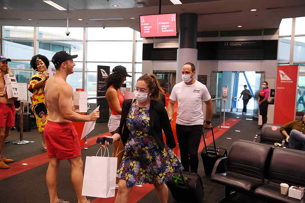 Passengers disembark from the first Qantas flight from Melbourne, Victoria, following the lifting of state border restrictions with New South Wales, at Sydney Airport in Sydney, Australia November 23, 2020. u00e2u20acu201d AAP via Reuters