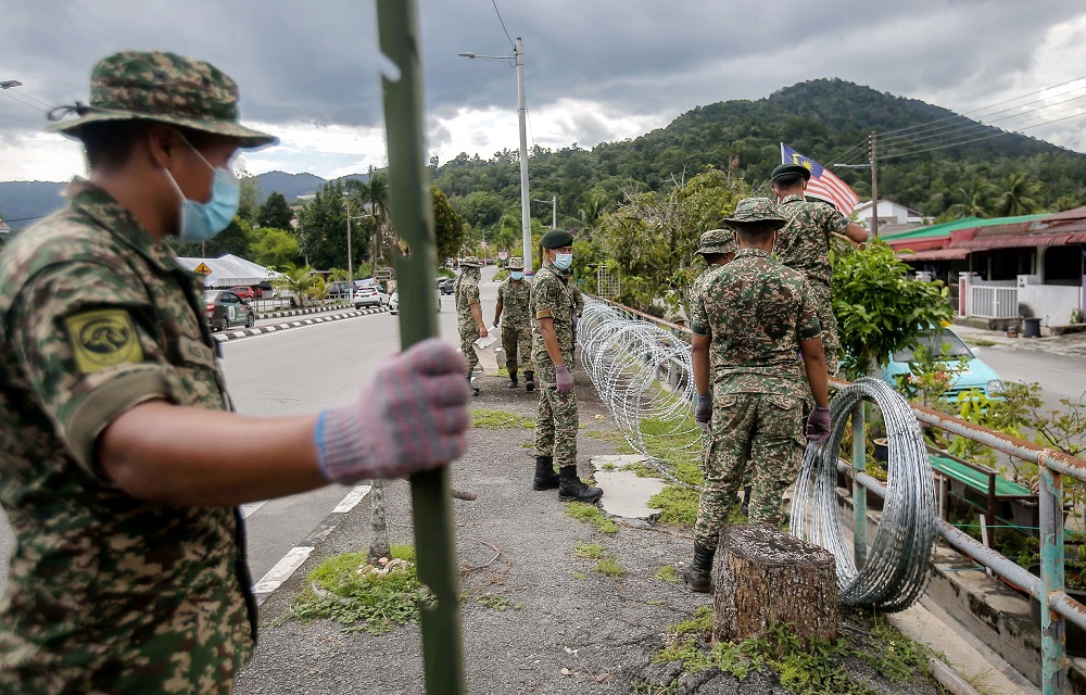 Armed Forces personnel are seen putting up barb wires at Zon B and Zon C of Taman Meru 2C in Ipoh that will be put under the enhanced movement control order (EMCO) for two weeks. u00e2u20acu2022 Picture by Farhan Najib 