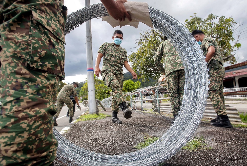 Armed Forces personnel are seen putting up barb wires at Zon B and Zon C of Taman Meru 2C in Ipoh that will be put under the enhanced movement control order (EMCO) for two weeks. u00e2u20acu2022 Picture by Farhan Najib 