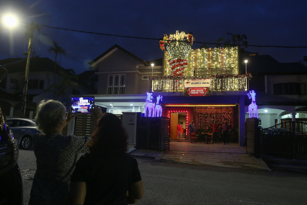 Neighbours pose against Ong’s house for a photo.