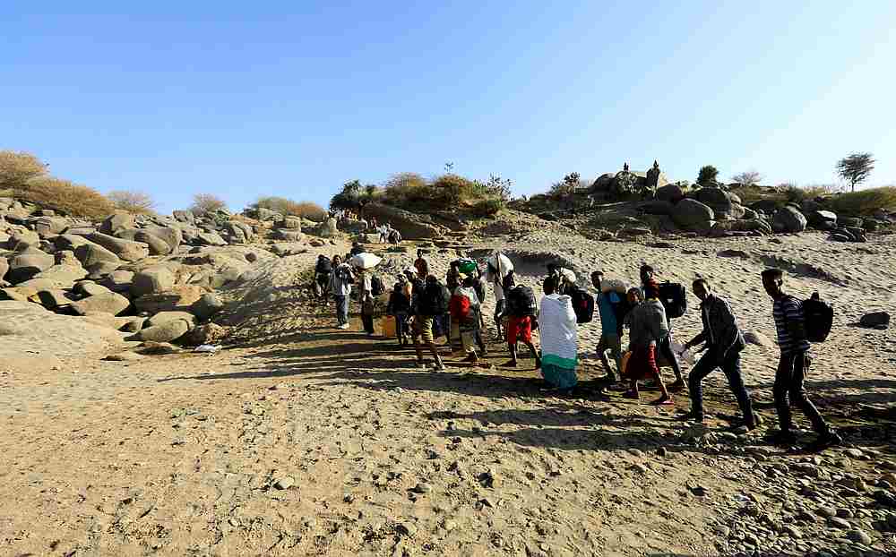 Ethiopians who fled the ongoing fighting in Tigray region, carry their belongings from a boat after crossing the Setit river in Hamdayet village in eastern Kassala state, Sudan November 22, 2020. u00e2u20acu201du00e2u20acu201d Reuters pic