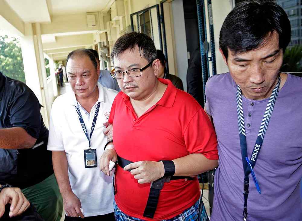 Teo Ghim Heng (second from right), who killed his wife and daughter, being escorted back to the crime scene on February 10, 2017. u00e2u20acu201d TODAY pic