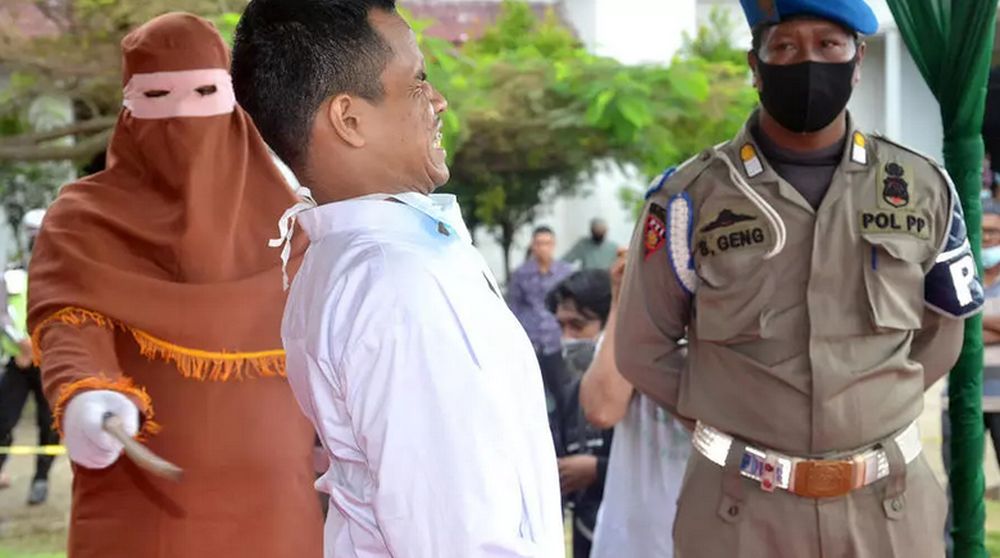 A man grimaces as he is flogged in Aceh, Indonesia, after being found guilty of raping a child. u00e2u20acu201d AFP pic