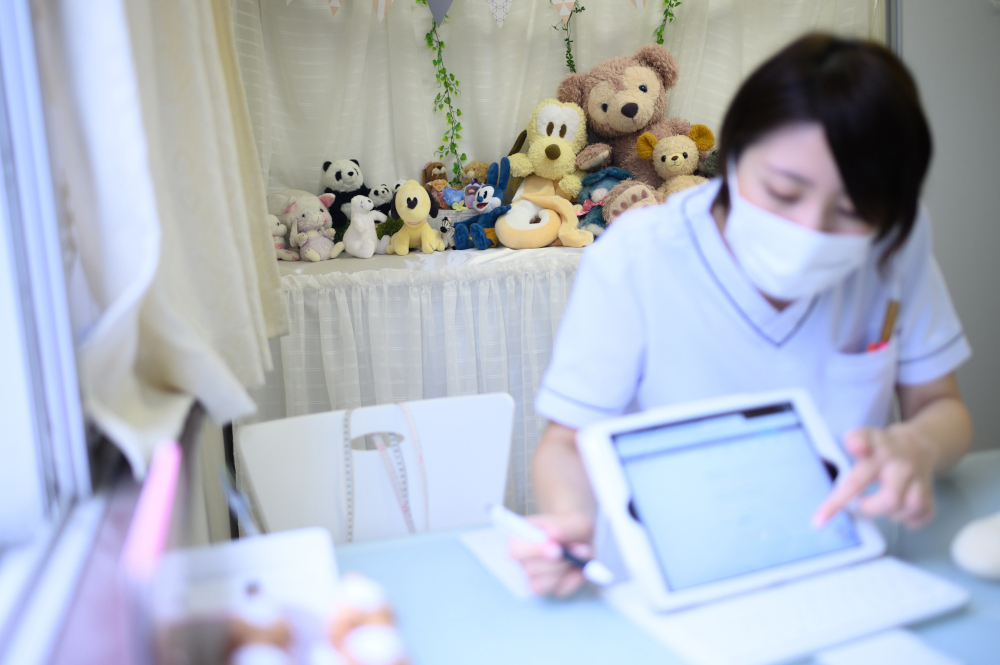 This photo taken September 13, 2020 shows general manager Minako Hirayama talking with client Yui Kato (not pictured) about the treatment for her stuffed toy sheep Yuki-chan at Natsumi Clinic in Tokyo. u00e2u20acu201d AFP pic 