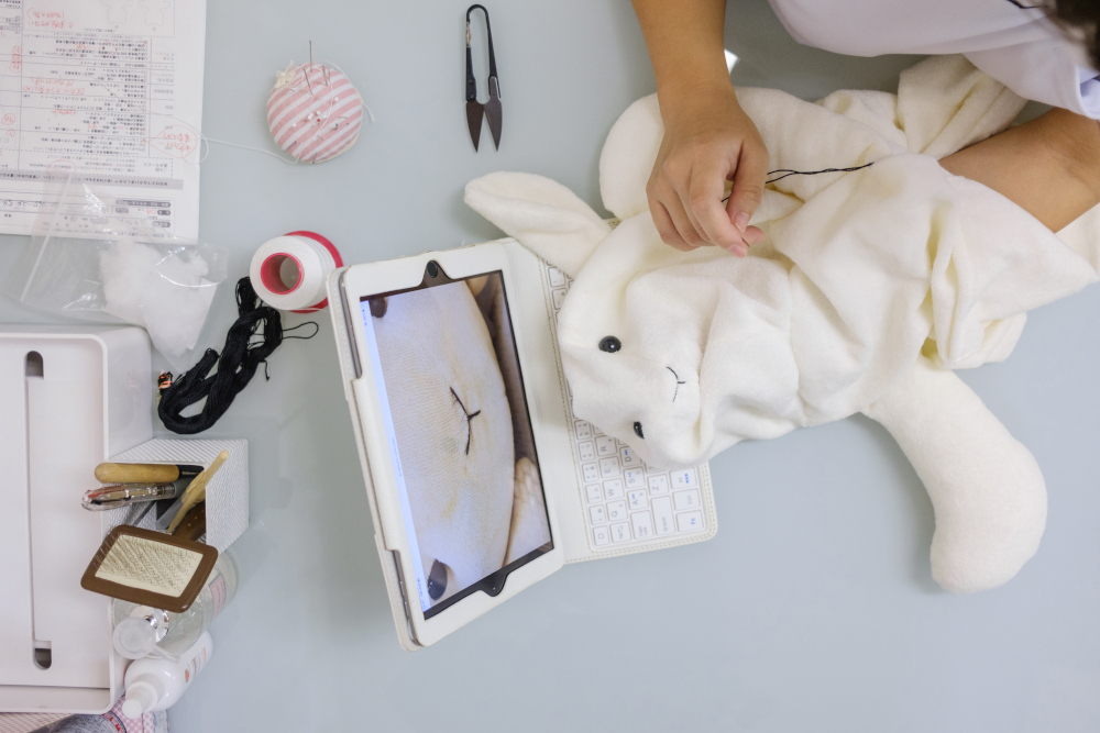 This photo taken September 18, 2020 shows an employee working on client Yui Kato’s stuffed toy sheep Yuki-chan at Natsumi Clinic in Tokyo. — AFP pic 