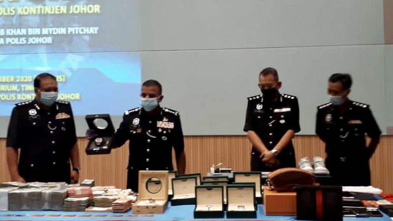 Johor police chief Datuk Ayob Khan Mydin Pitchay (second left) inspecting the cash and valuables seized in the raid of a house belonging to an investment scam suspect during a press conference in Johor Baru today. u00e2u20acu201d Picture by Ben Tan