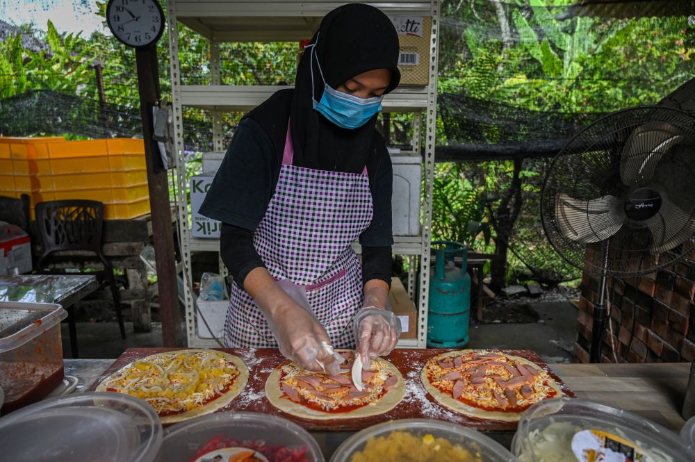 A worker preparing pizza ingredients at the Jemapoh Pizza Kayu Api restaurant in Jemapoh,  Negri Sembilan November 5, 2020. u00e2u20acu2022 AFP pic