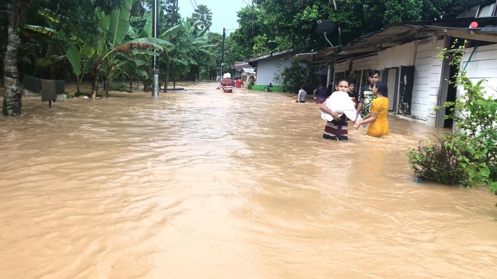 Firemen making their way to rescue several flood victims at Jalan Permatang Utama, Kampung Kempas Baru after several homes were submerged by flood waters. u00e2u20acu201d Picture courtesy of the Johor Fire and Rescue Department