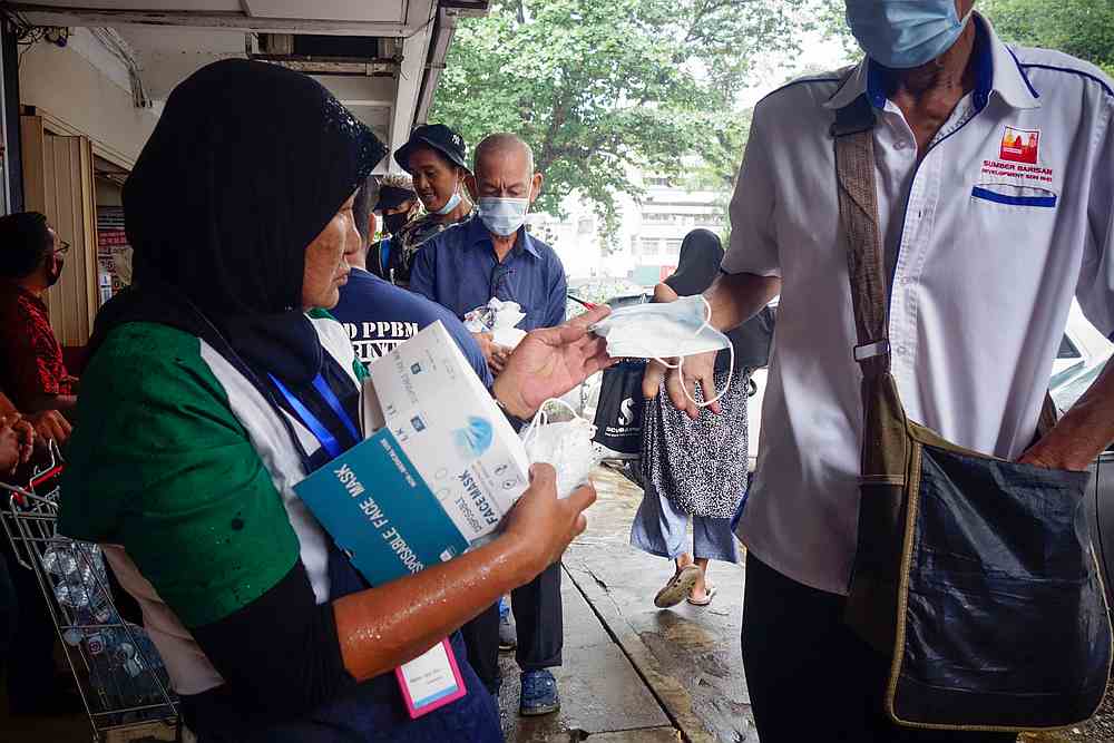Mak Wan distributes facemask to the homeless. — Picture by Shafwan Zaidon