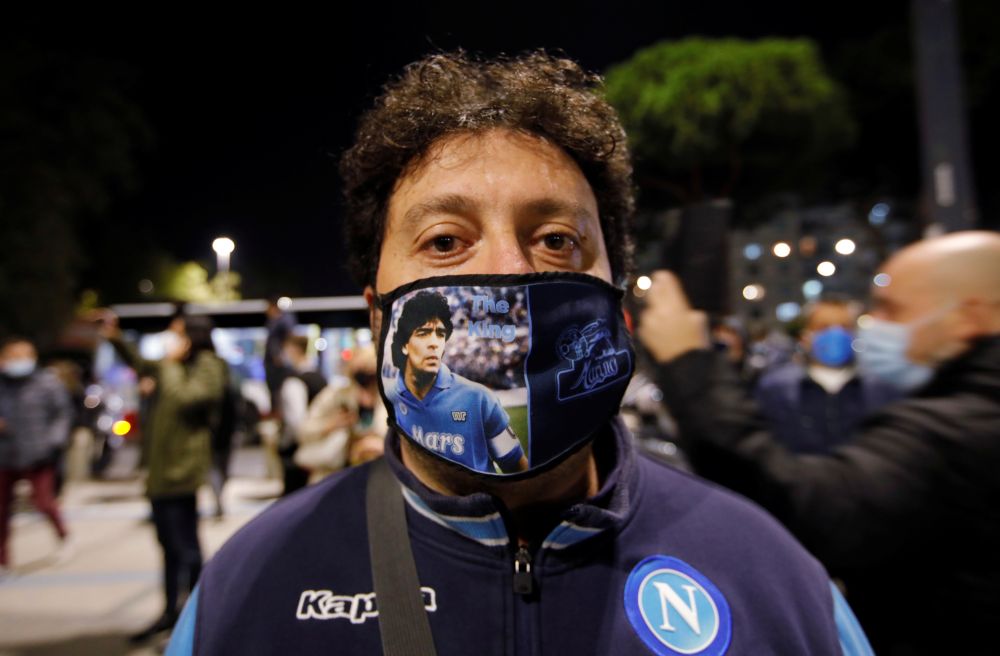 A man wears a face mask as people gather to mourn the death of Argentine football legend Diego Maradona outside San Paolo stadium in Naples November 25, 2020. u00e2u20acu201d Reuters picnn