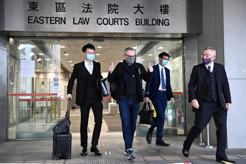 Swiss photographer Marc Progin (2nd L), 75, gestures upon leaving the Eastern Magistrates Court in Hong Kong November 13, 2020. — AFP pic