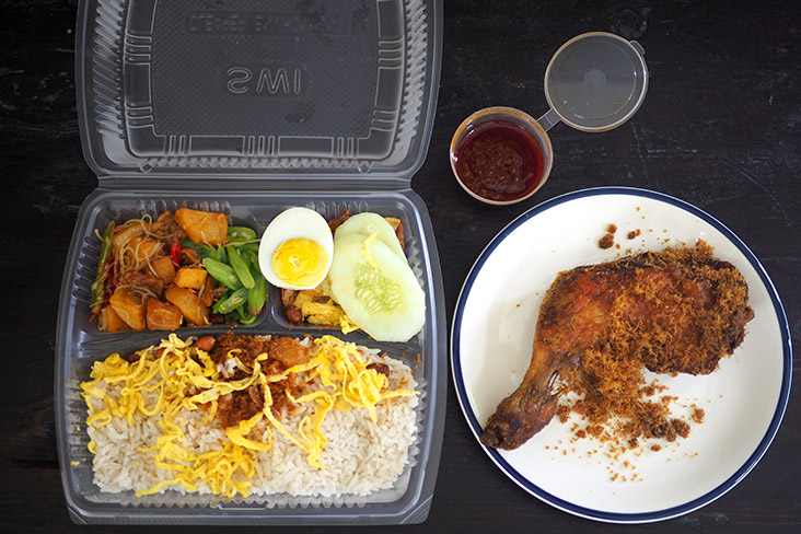 The 'nasi lemak' comes in two packages, one is a divided box for the various elements and another is a brown paper bag for the fried chicken