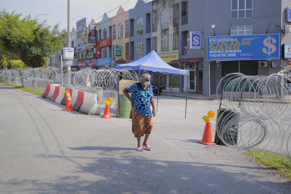 A woman walks past barbed wire fencing amid the enhanced movement control order in Medan 88, Salak Tinggi November 12, 2020. u00e2u20acu201d Picture by Shafwan Zaidon