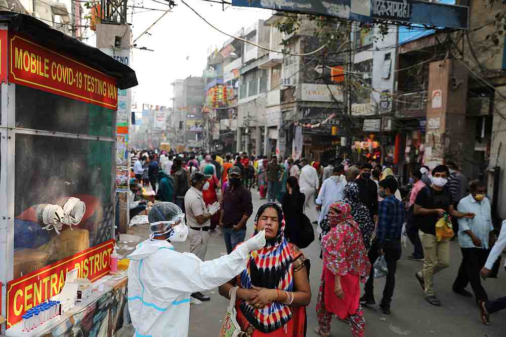 A healthcare worker collects a swab sample from a woman amid the spread of Covid-19, at a market, in the old quarters of Delhi, India November 13, 2020. u00e2u20acu201d Reuters pic