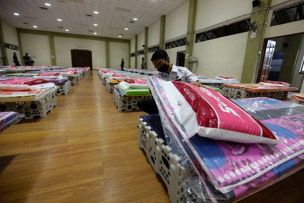 A Penang State Health Department personnel is pictured arranging beds for the placement of low-risk Covid-19 patients at the Caring Society Complex in George Town November 18, 2020. u00e2u20acu201d Picture by Sayuti Zainudin
