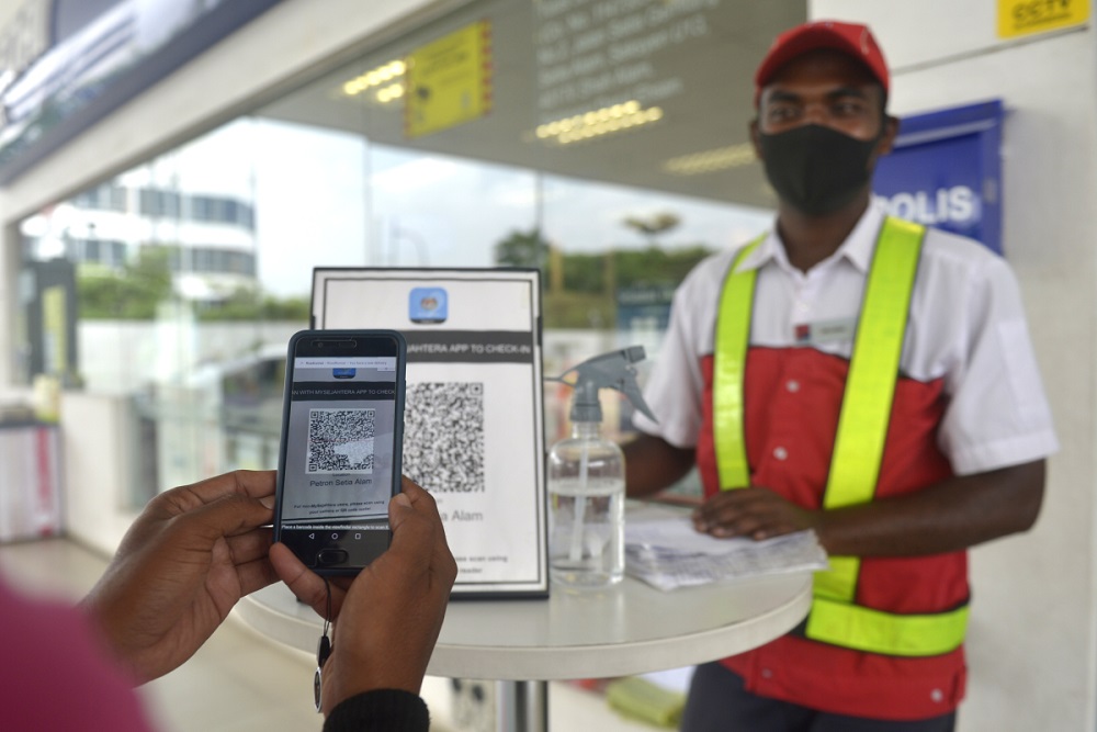 Customers scan the MySejahtera app before entering the premise of a petrol station in Setia Alam November 10, 2020. u00e2u20acu2022 Picture by Miera Zulyana