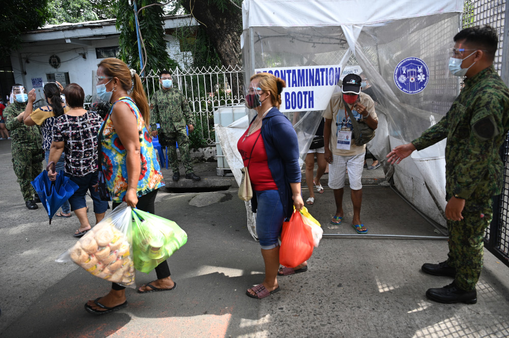 Residents through a contamination booth as they arrive to pray at their relativesu00e2u20acu2122 grave ahead of a weeklong closure of cemeteries on the annual observance of All Saintsu00e2u20acu2122 Day in Manila October 28, 2020. u00e2u20acu201d AFP pic 
