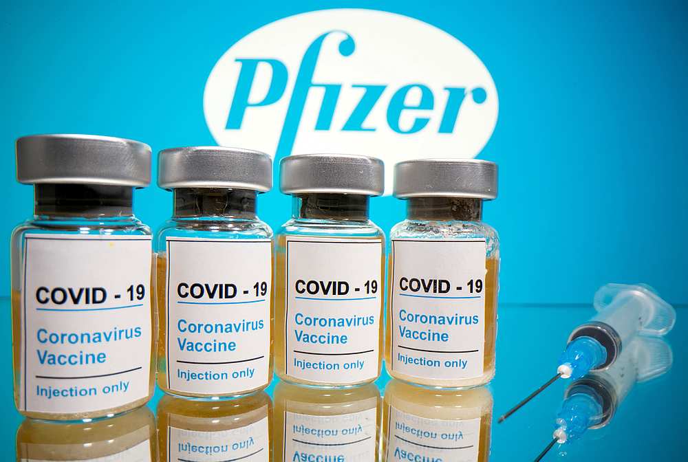Vials containing Covid-19 vaccine seen in front of a displayed Pfizer logo in this illustration October 31, 2020. — Reuters pic