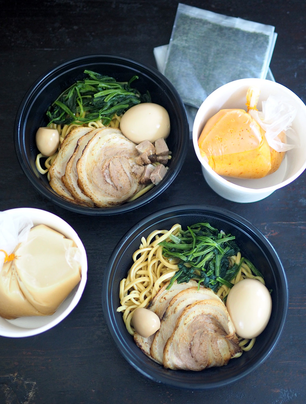 The broth is placed in a plastic bag and container, noodles with toppings in another container and the seaweed sheets in a plastic bag to prevent it from softening.