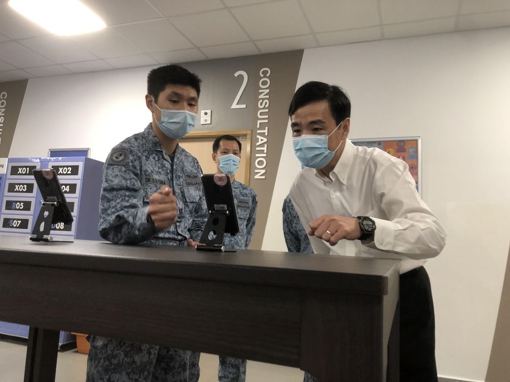 Heng Chee How (right), Senior Minister of State for Defence, testing a new app on trial at the Tengah Air Base medical centre. — TODAY pic