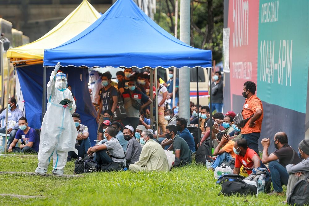 Sky Meridien construction workers wait to be transported to the Sungai Buloh and Kuala Lumpur hospitals after several tested positive for Covid-19 November 29, 2020.  u00e2u20acu201d Picture by Ahmad Zamzahuri