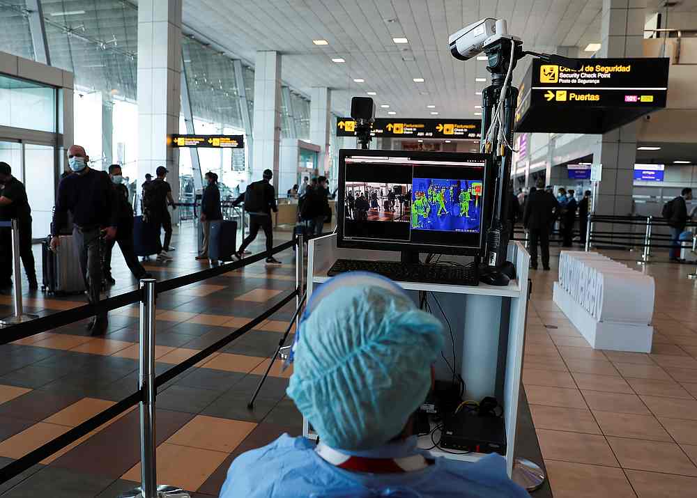 A healthcare worker measures the temperatures of travellers at the Tocumen International Airport during the Covid-19 outbreak, in Panama City, Panama October 16, 2020. u00e2u20acu201d Reuters pic