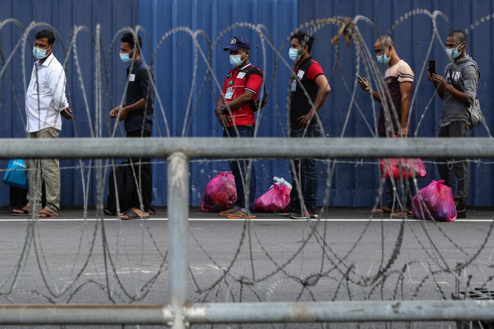 Top Glove workers wait in line outside staff dormitories in Klang before being transported to the Sungai Buloh Hospital November 26, 2020. u00e2u20acu201d Picture by Yusof Mat Isa