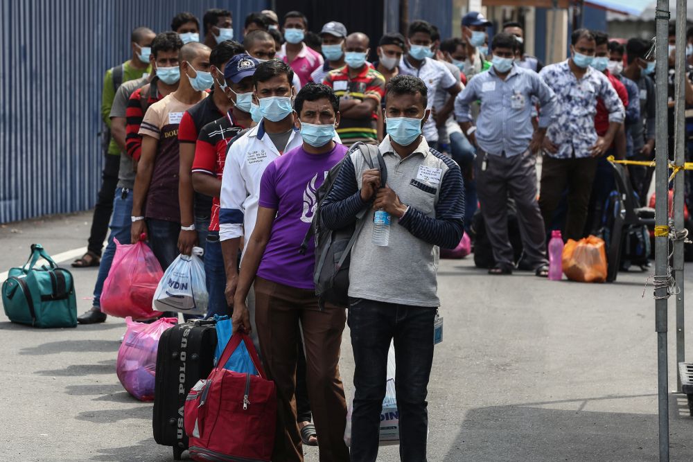 Top Glove workers wait in line outside staff dormitories in Klang before being transported to the Sungai Buloh Hospital November 26, 2020. u00e2u20acu201d Picture by Yusof Mat Isa