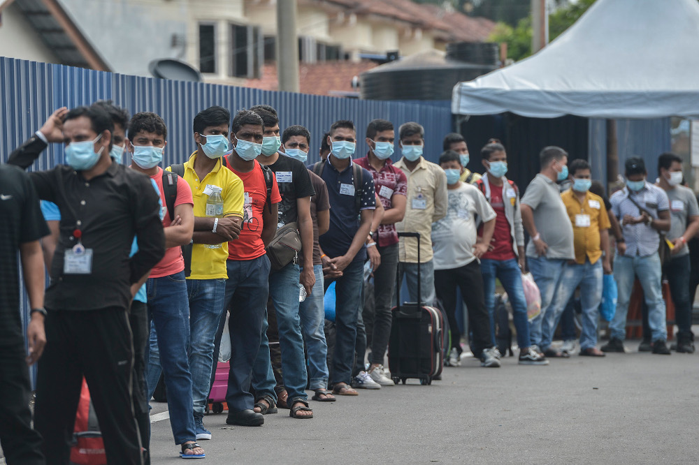 Top Glove workers lining up outside workersu00e2u20acu2122 dormitories to be taken to Covid 19 isolation centres November 26,  2020. u00e2u20acu201d Picture by Miera Zulyana