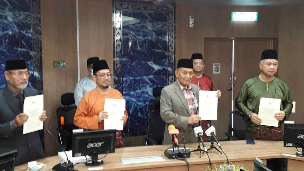 Johor Islamic Religious Affairs Committee chairman Tosrin Jarvanthi (3rd left) showing a copy of the summons letters that have been sent out to three Hizbut Tahrir Malaysia (HTM) followers in Johor Baru November 12, 2020. u00e2u20acu201d Picture by Ben Tan